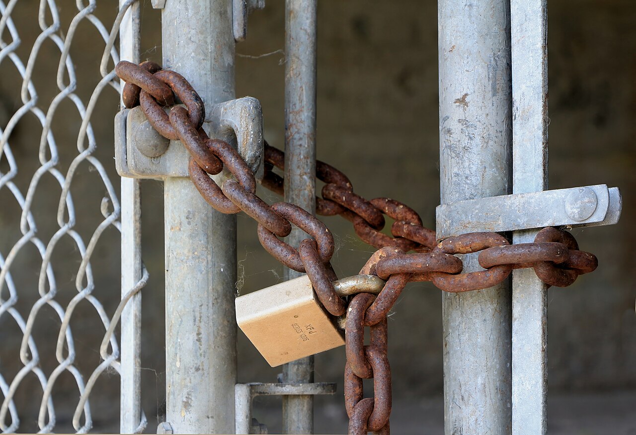 A heavy steel padlock securing a chain &mdash; visual metaphor for credit-freeze protection during utility signup.