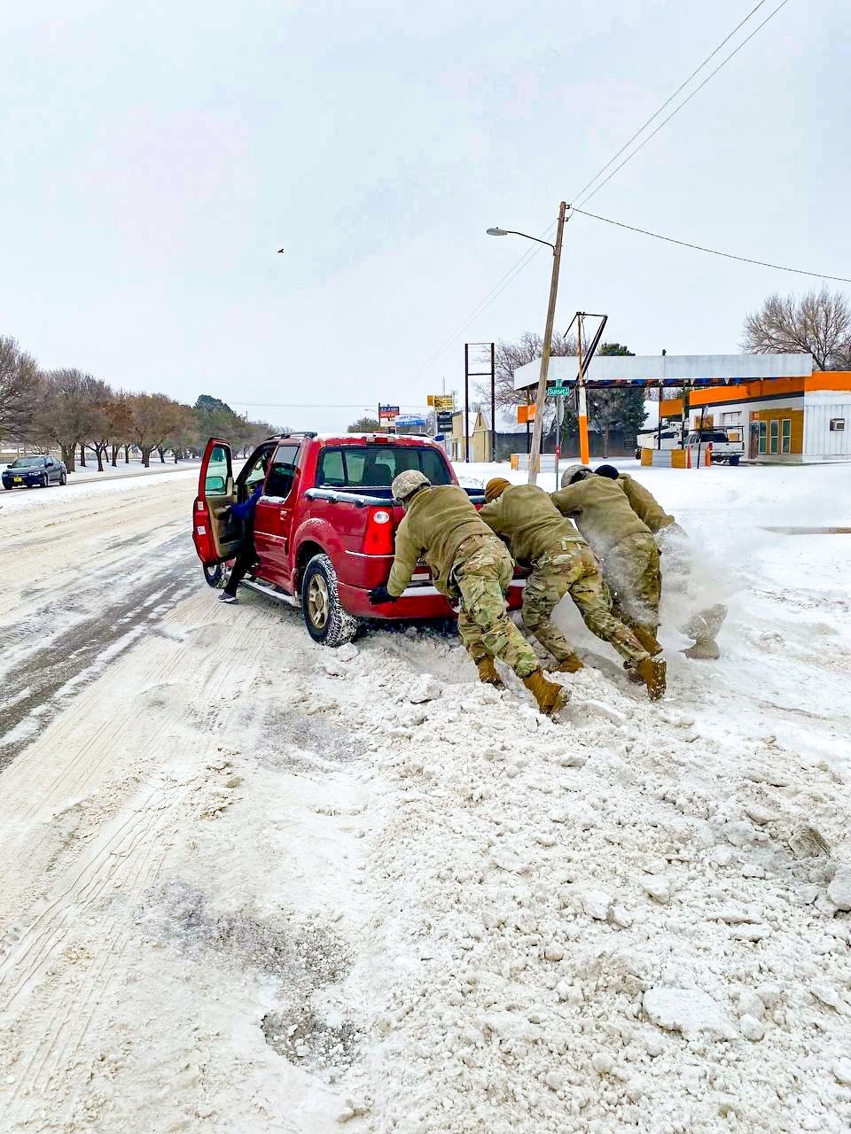 A car stuck in deep snow during the February 2021 Texas winter storm in Abilene — Texas National Guard photo.
